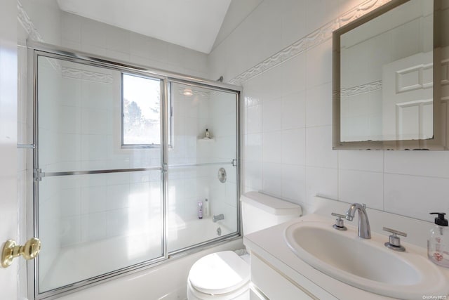 full bathroom with enclosed tub / shower combo, vaulted ceiling, decorative backsplash, vanity, and tile walls