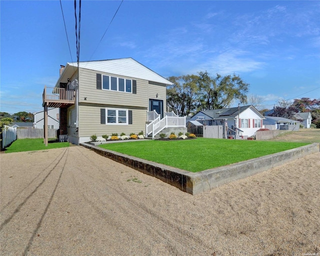 view of front facade featuring a balcony and a front lawn