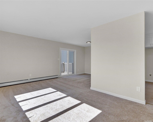 empty room featuring light colored carpet and a baseboard heating unit