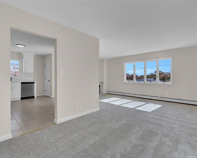 carpeted empty room with baseboard heating and a wealth of natural light