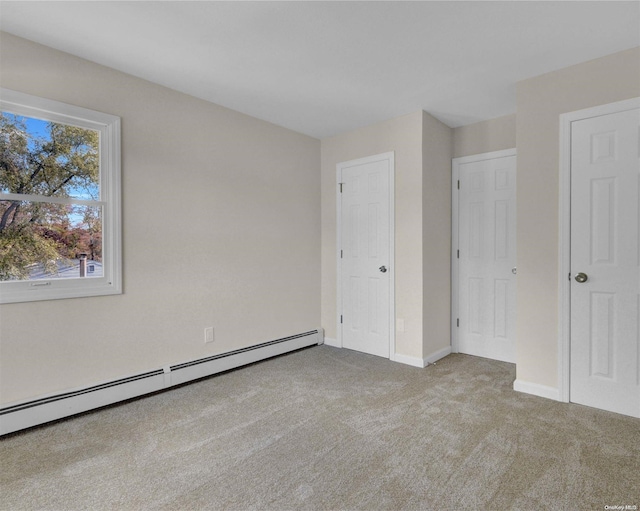 unfurnished bedroom with light carpet and a baseboard radiator