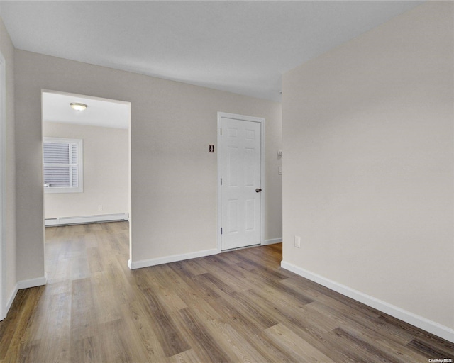 unfurnished room with light hardwood / wood-style floors and a baseboard radiator