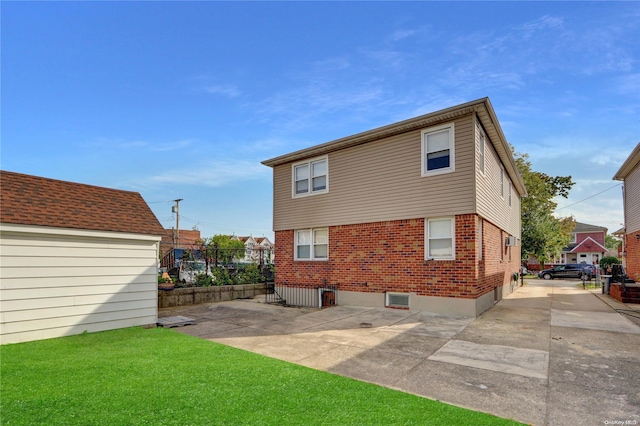 back of house featuring a lawn and a patio area