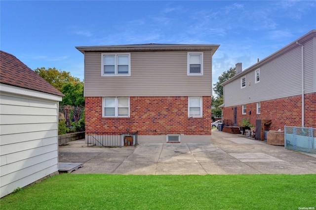 back of house featuring a lawn and a patio