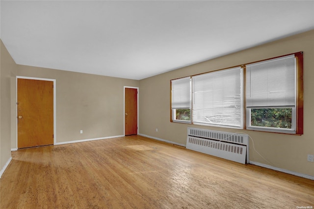 unfurnished room featuring light hardwood / wood-style flooring and radiator