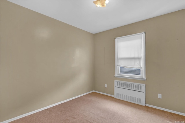 unfurnished room featuring carpet flooring and radiator