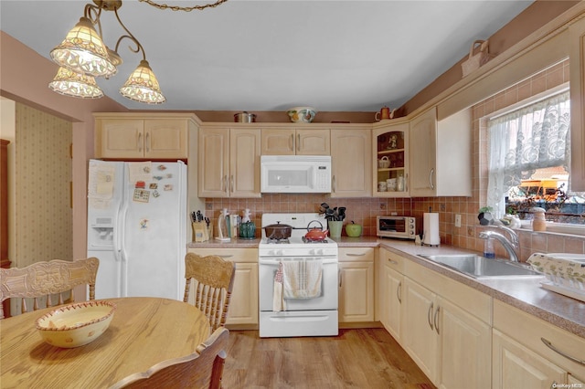 kitchen featuring sink, hanging light fixtures, light hardwood / wood-style flooring, white appliances, and decorative backsplash