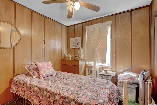 bedroom with radiator heating unit, ceiling fan, and wooden walls