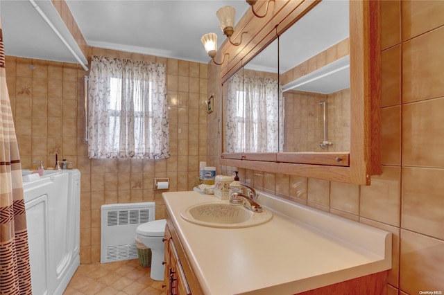 bathroom featuring tile patterned flooring, radiator, and tile walls