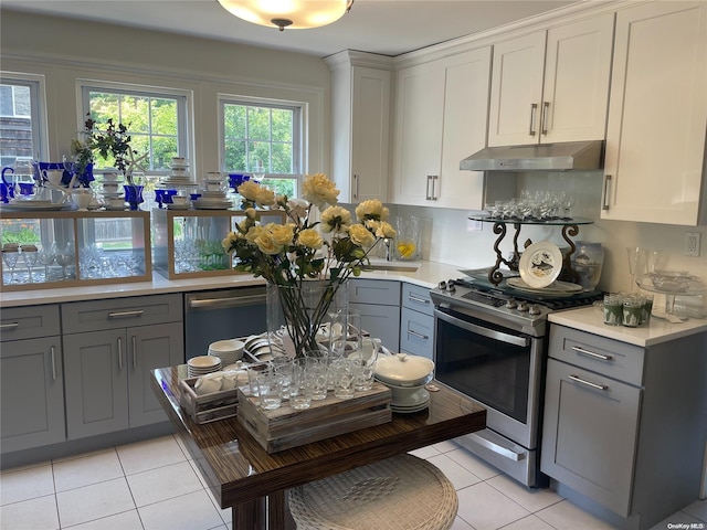 kitchen featuring white cabinets, stainless steel appliances, gray cabinetry, and light tile patterned flooring