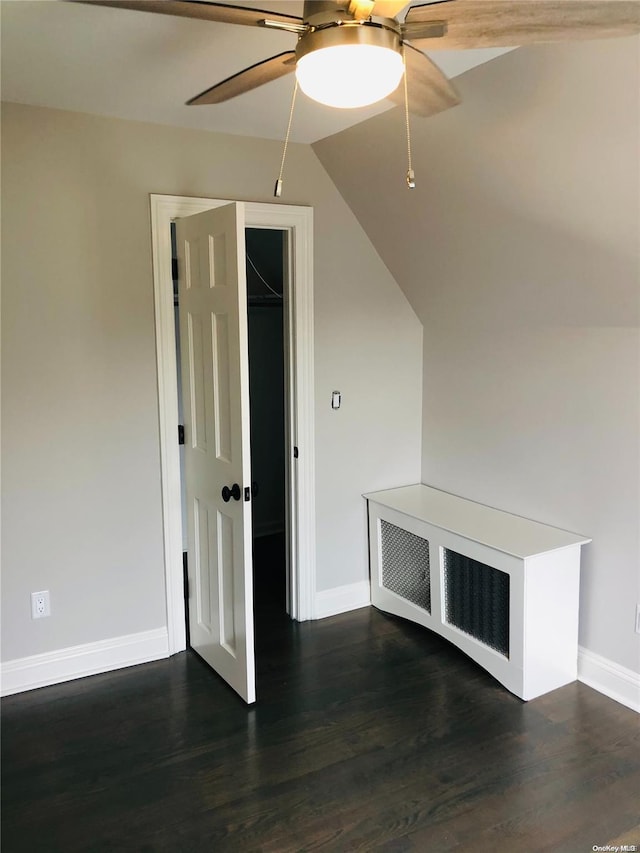 interior space featuring ceiling fan, dark wood-type flooring, and lofted ceiling