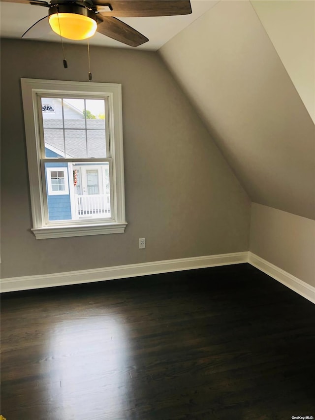 additional living space with dark hardwood / wood-style flooring, vaulted ceiling, and ceiling fan