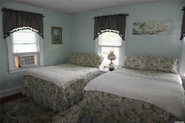 bedroom featuring multiple windows, cooling unit, and hardwood / wood-style floors