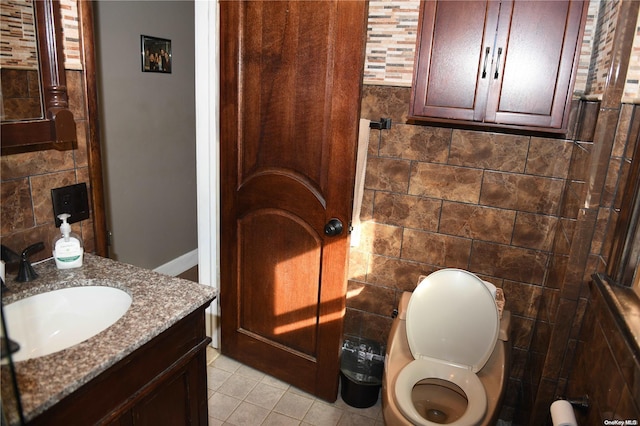 bathroom with tile patterned floors, vanity, toilet, and tile walls