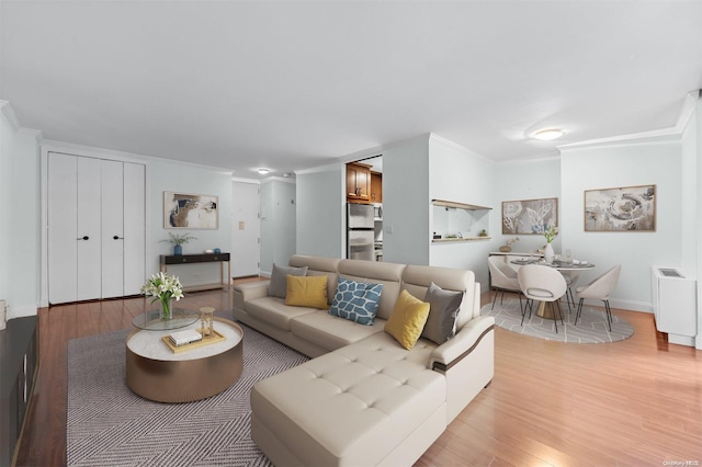 living room featuring light wood-type flooring and crown molding