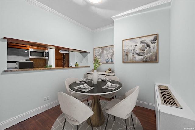 dining area with crown molding and dark hardwood / wood-style floors