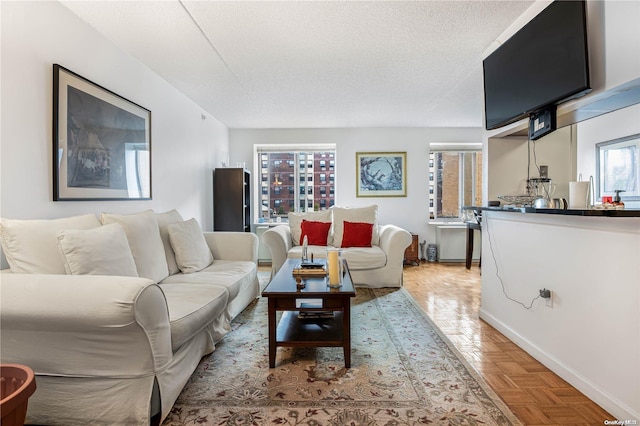 living room featuring a textured ceiling and light parquet flooring