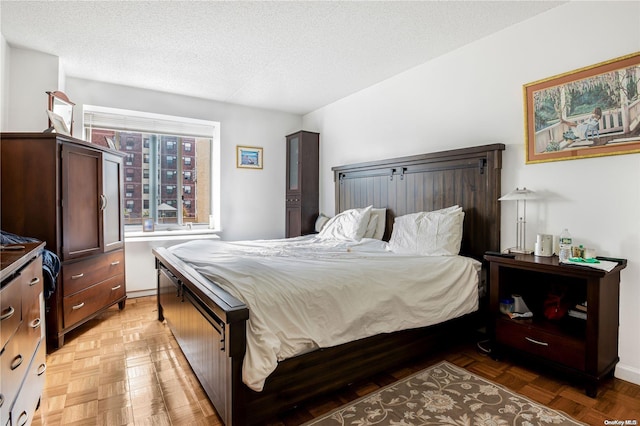 bedroom with a textured ceiling and parquet flooring