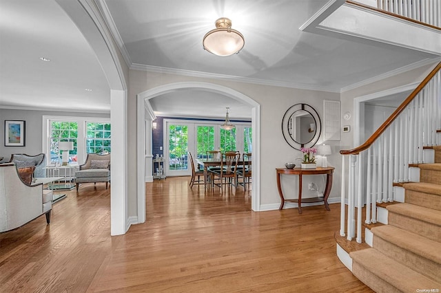 entryway with crown molding and light wood-type flooring