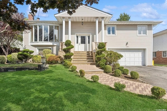 back of house featuring a garage and a lawn