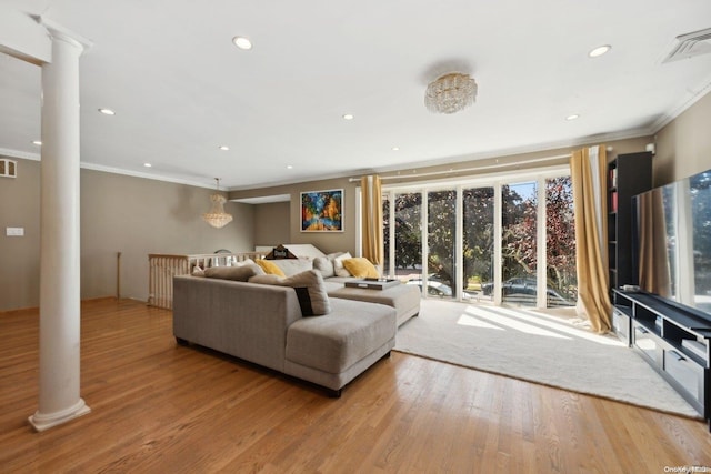 living room featuring decorative columns, light hardwood / wood-style flooring, and crown molding