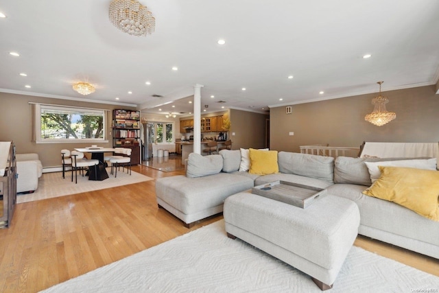 living room with a chandelier, ornamental molding, a baseboard radiator, and light wood-type flooring