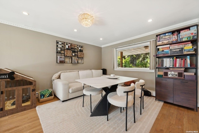 dining area featuring a notable chandelier, crown molding, and light hardwood / wood-style flooring