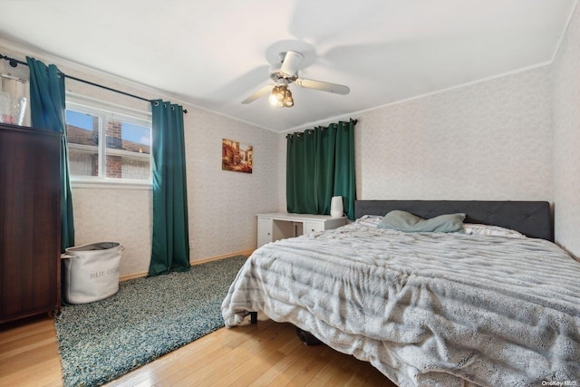 bedroom with ceiling fan, crown molding, and hardwood / wood-style flooring