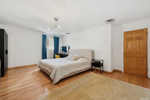 bedroom featuring a chandelier and hardwood / wood-style flooring