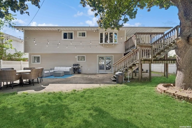 back of house with outdoor lounge area, a deck, a patio area, and a lawn