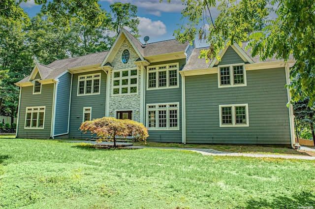 rear view of property featuring a lawn