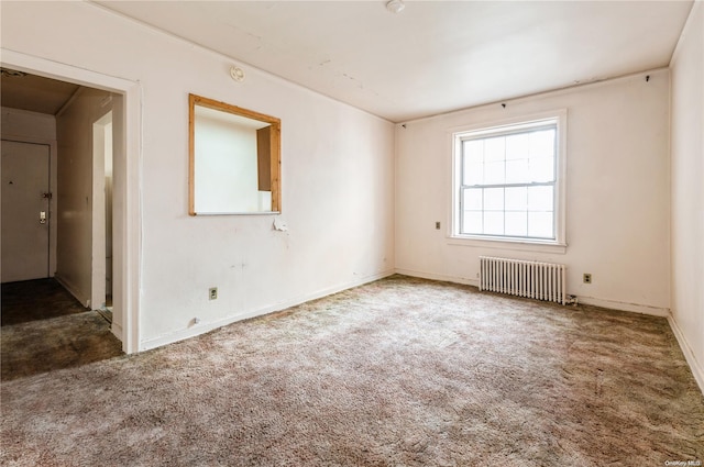 carpeted spare room with radiator heating unit