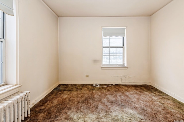 carpeted empty room with radiator heating unit