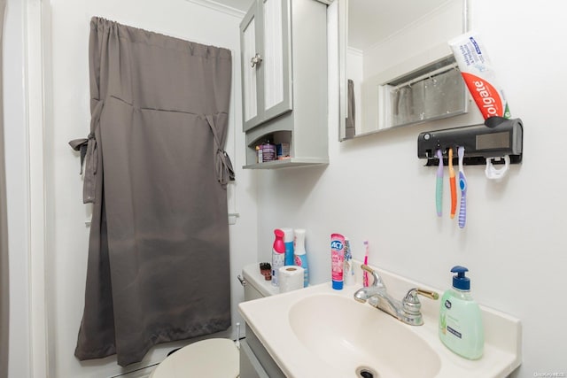 bathroom with vanity, toilet, and crown molding