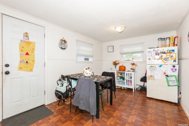 dining space with dark parquet flooring and ornamental molding