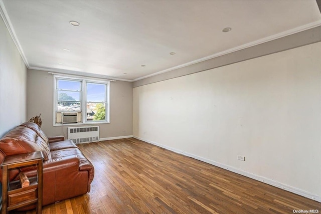 sitting room featuring cooling unit, wood-type flooring, ornamental molding, and radiator