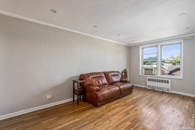 sitting room featuring radiator, hardwood / wood-style floors, cooling unit, and ornamental molding