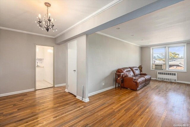 unfurnished room featuring hardwood / wood-style floors, radiator, an inviting chandelier, cooling unit, and ornamental molding