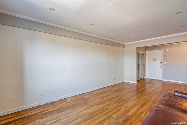 unfurnished living room featuring ornamental molding and light hardwood / wood-style flooring