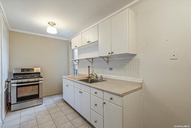 kitchen with white cabinets, gas range, crown molding, and sink