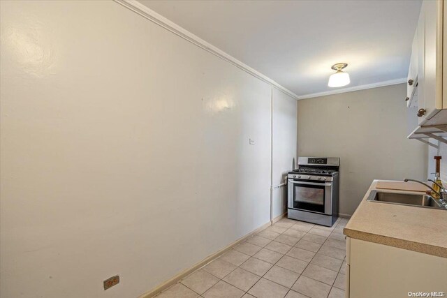 kitchen featuring light tile patterned floors, sink, ornamental molding, and stainless steel range with gas stovetop