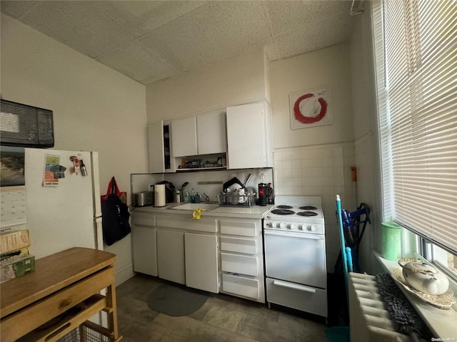 kitchen featuring backsplash, white range, sink, radiator heating unit, and white cabinetry