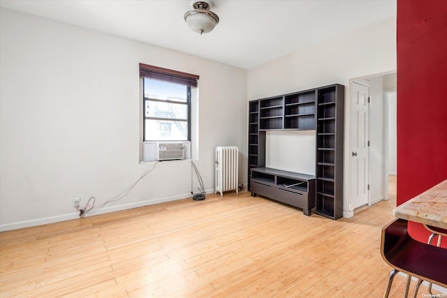 living room featuring hardwood / wood-style flooring, cooling unit, and radiator heating unit