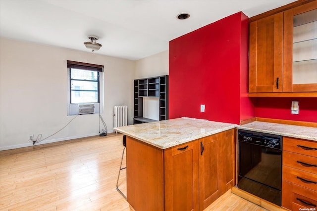 kitchen with radiator, light hardwood / wood-style flooring, black dishwasher, light stone counters, and a breakfast bar area