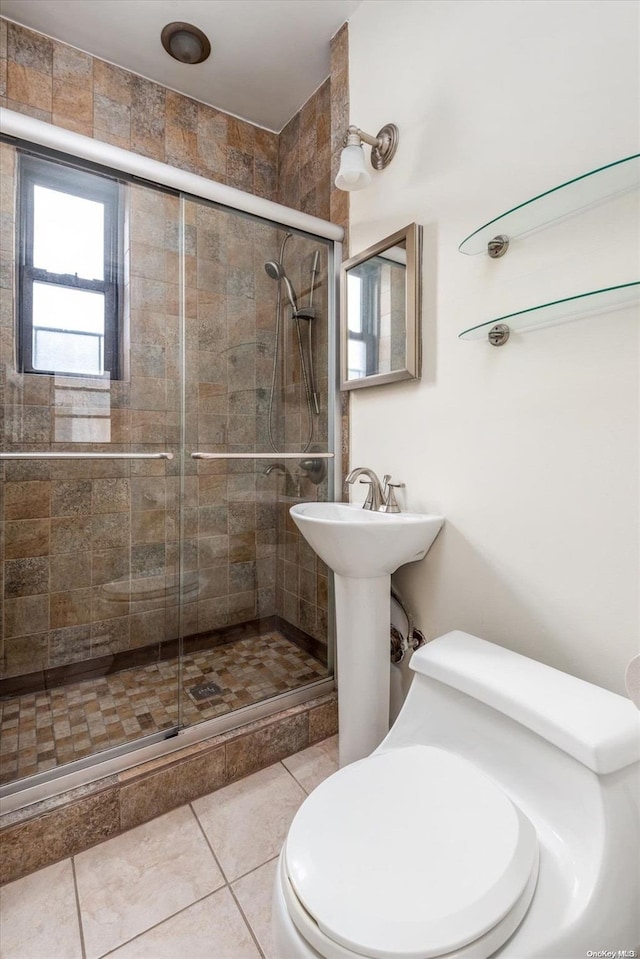 bathroom with tile patterned flooring, a shower with shower door, and toilet