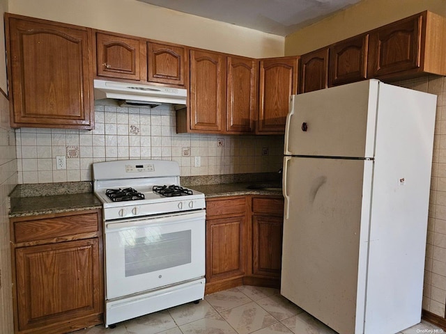 kitchen featuring decorative backsplash and white appliances