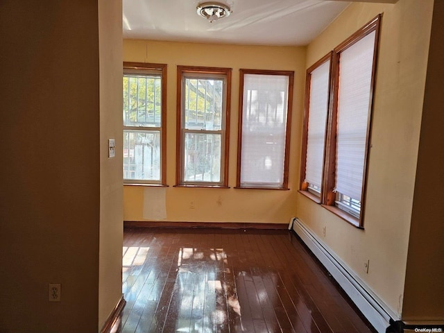 interior space featuring dark wood-type flooring and a baseboard heating unit