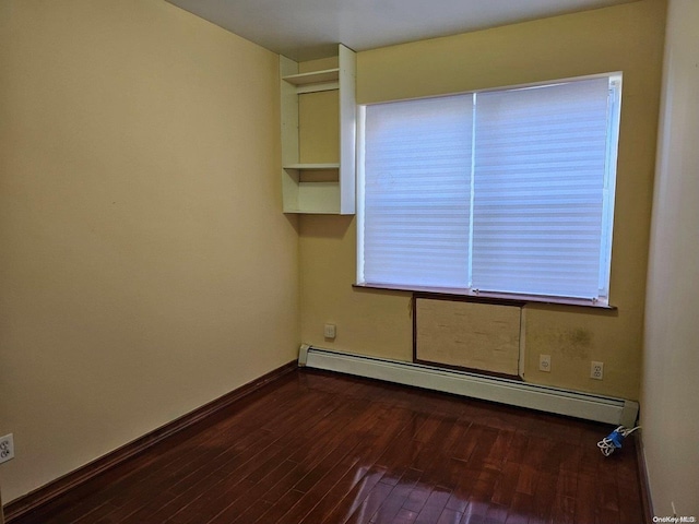 spare room with wood-type flooring and a baseboard radiator