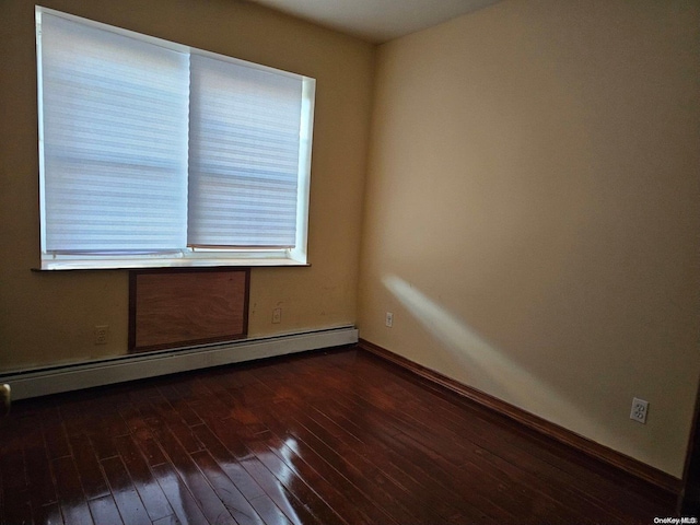 empty room featuring dark hardwood / wood-style floors and a baseboard radiator