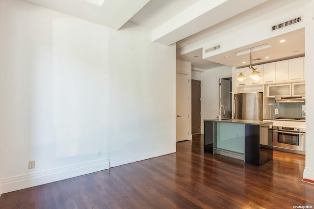 kitchen with dark hardwood / wood-style flooring, white cabinetry, hanging light fixtures, and stainless steel appliances